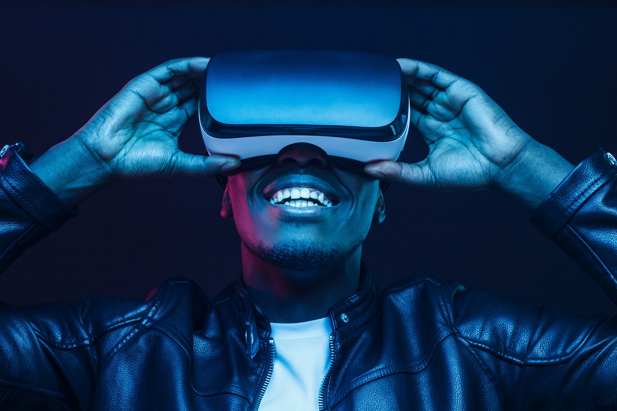 Un homme africain portant un casque de réalité virtuelle s'amusant beaucoup.