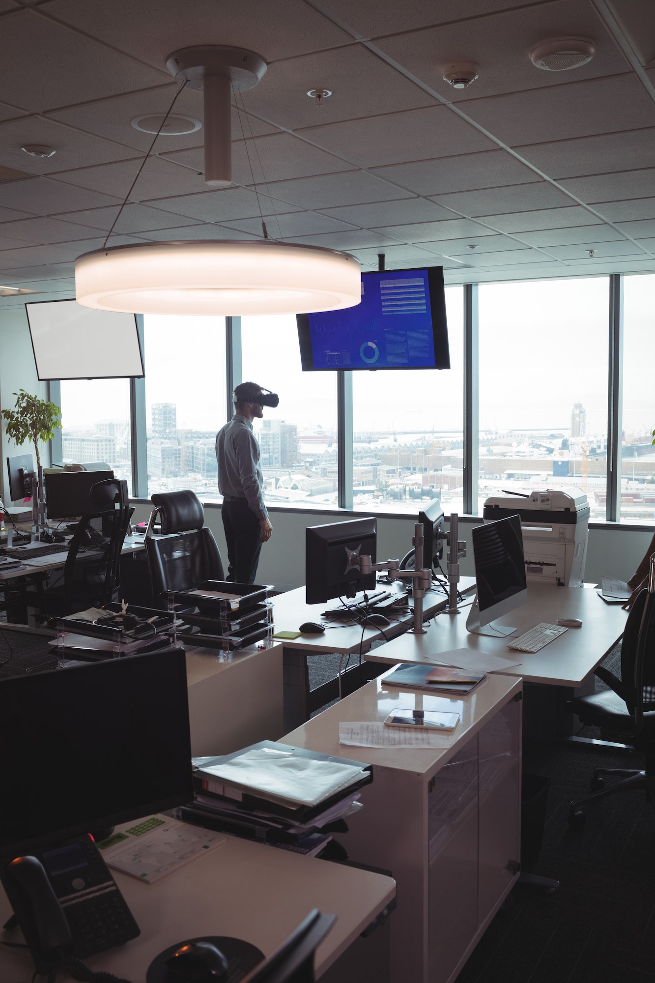 Un hombre de negocios utilizando unas gafas de realidad virtual junto a un escritorio